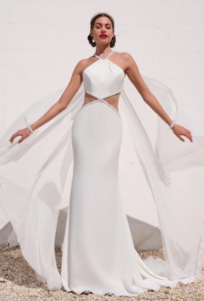 In questa foto una modella indossa un abito da sposa a sirena 2024 di Mysecret Sposa con cut out sul busto e scollatura all'americana