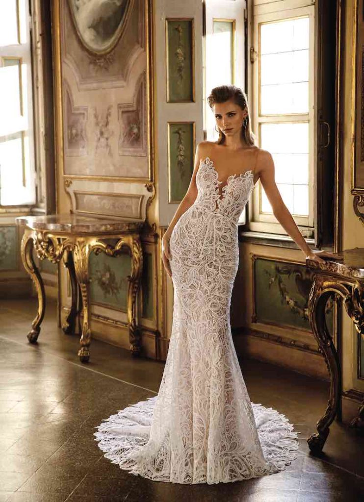 In questa foto una modella indossa uno dei modelli di abiti da sposa a sirena 2024 PenLiv in pizzo Guipuree scollo a V effetto illusion