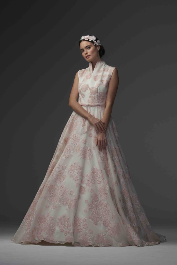 In questa immagine un abito da sposa colorato 2024 di Chiara Vitale con maxi fiori rosa ricamati. 