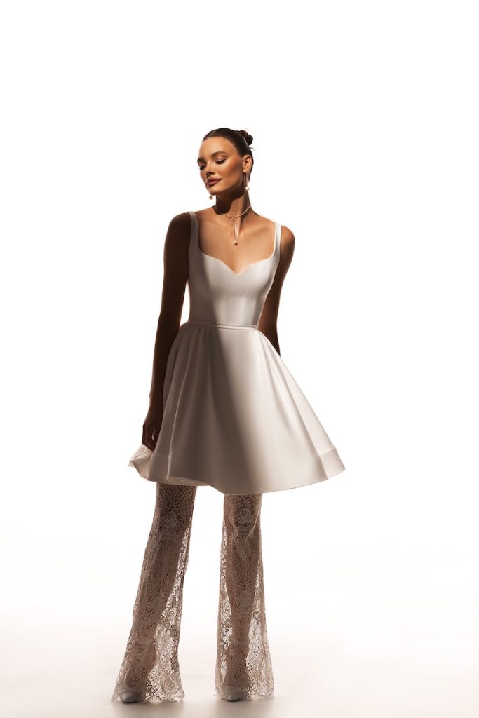 In questa foto una modella indossa un abito da sposa con gonna a ruota e leggins di Katy Corso