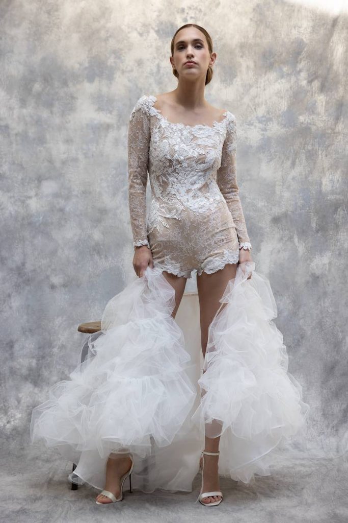 In questa foto una modella indossa una tuta da sposa in pizzo con shorts di Cymbeline
