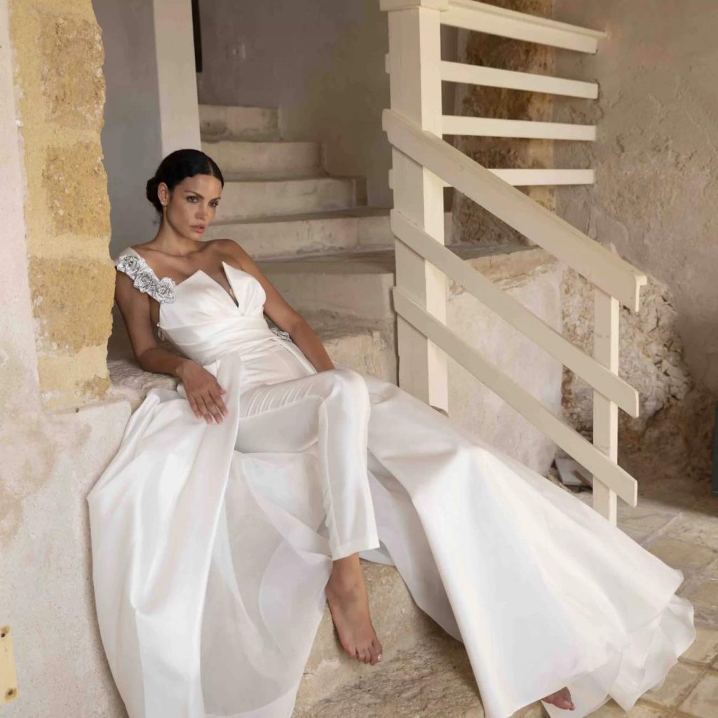 In questa foto una modella indossa una tuta da sposa di Alessandro Angelozzi con sopragonna