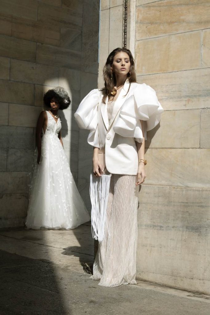 In questa foto una modella indossa uno degli abiti da sposa con pantaloni 2024 Le Fate Milano con blazer dalle maniche over