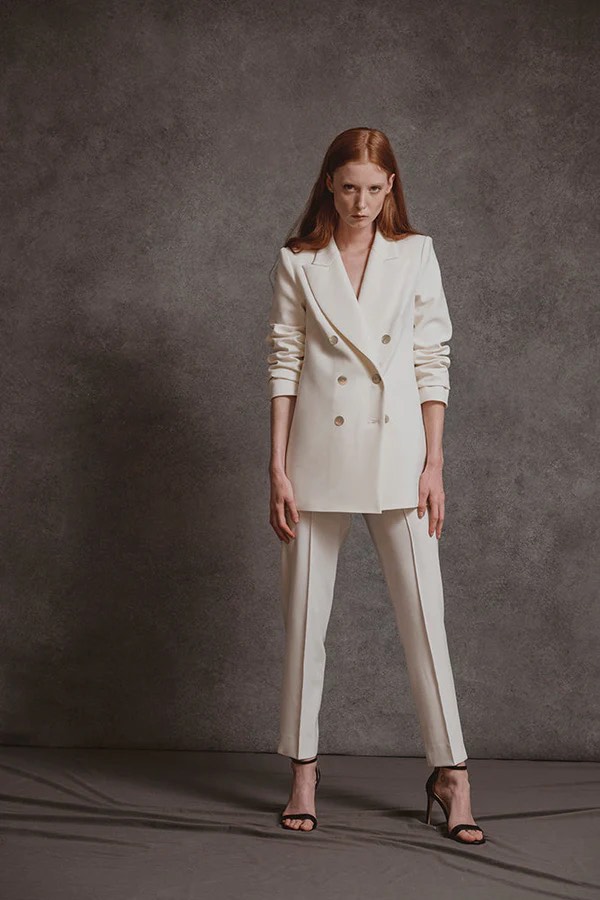 In questa una modella indossa uno degli abiti da sposa con pantaloni 2024 di Sophie et Voilà con blazer abbinato 