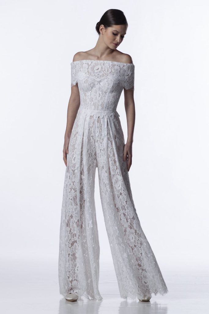 In questa una modella indossa una jumpsuit da sposa 2024 in pizzo di Valentini Spose