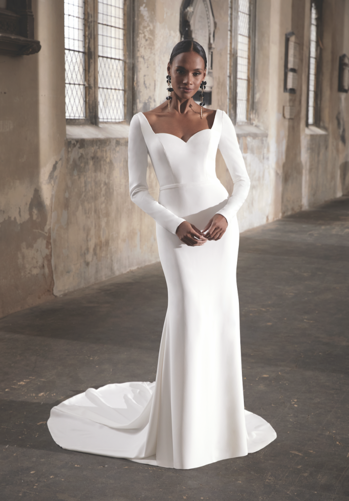 In questa immagine un modello di abiti da sposa semplici 2024 di Justin Alexander con maniche lunghe e scollo a cuore. 
