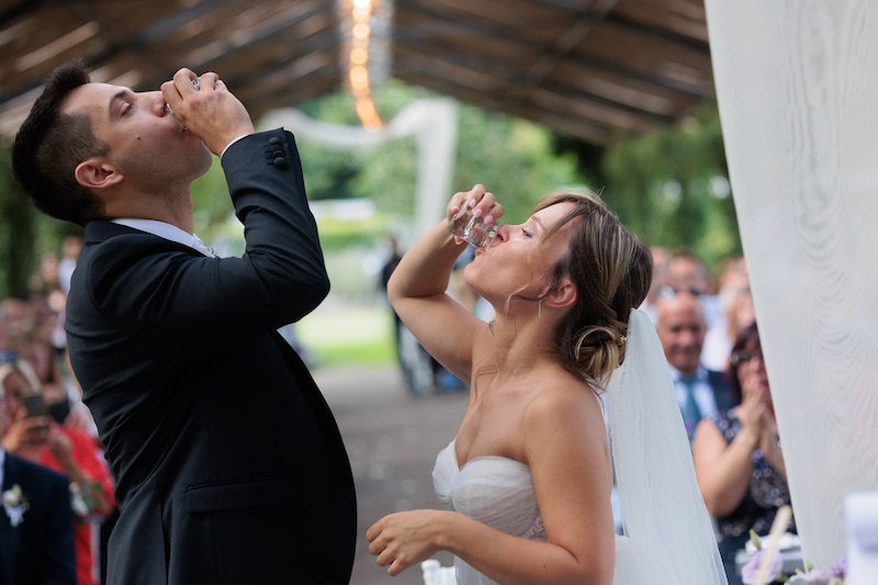 In questa foto due sposi bevono due shots durante il loro matrimonio