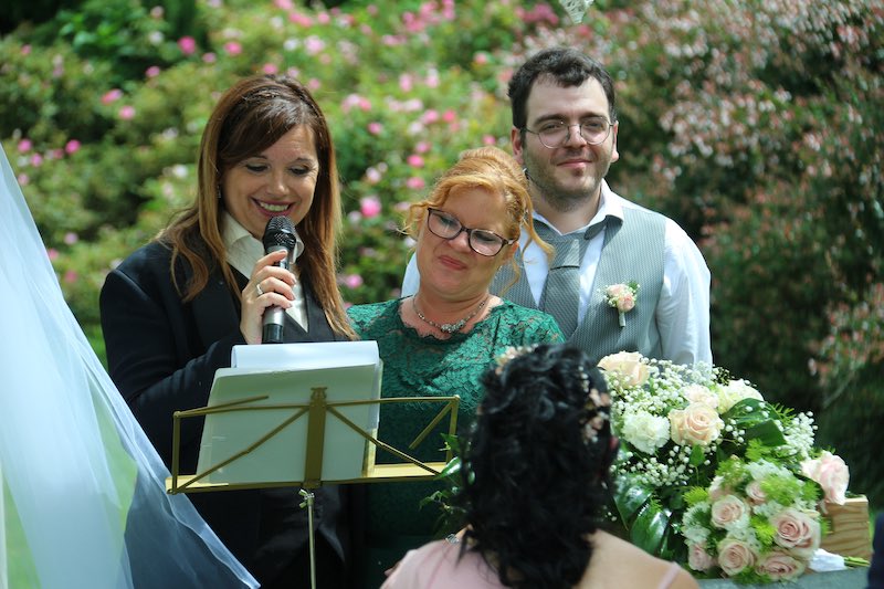 In questa foto Gabriella Maran aiuta due testimoni a leggere i loro discorsi a due sposi durante la cerimonia di nozze