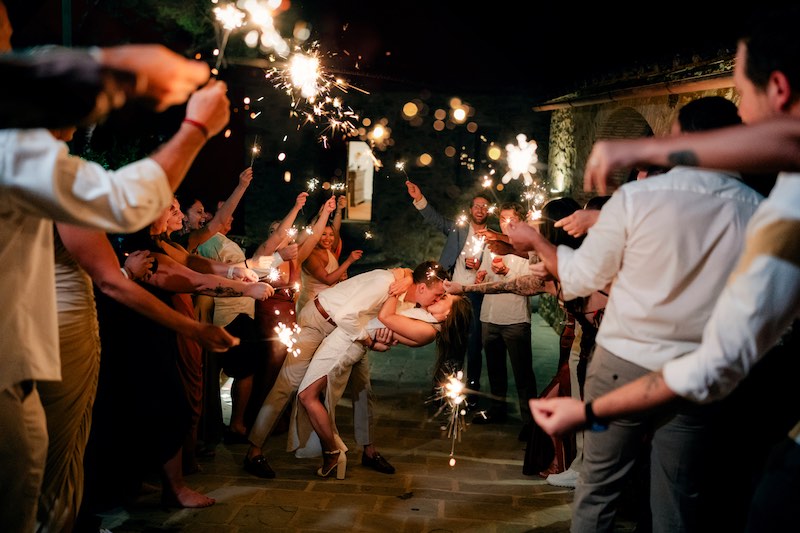 In questa foto notturna di Claudio Fasci due sposi si fanno il casqué circondati dalle stelline luminose tenute in alto da tutti gli invitati