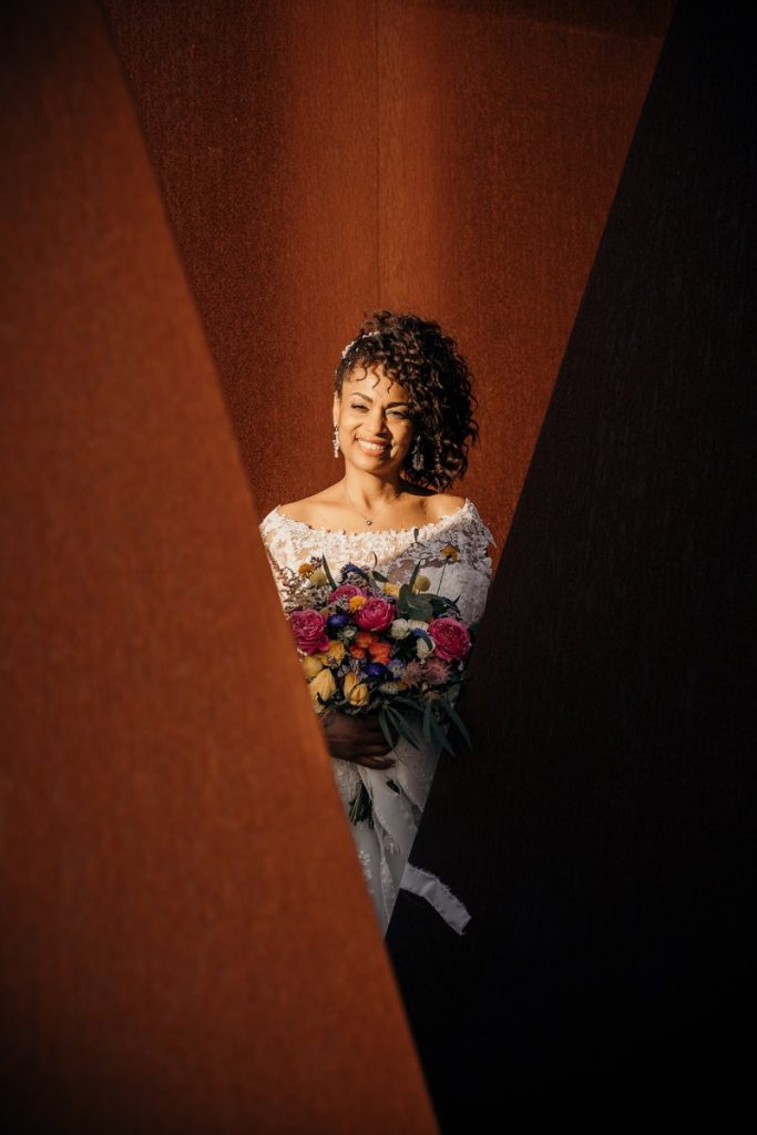In questo foto di Claudio Fasci una sposa sorride tra piani triangolari di colore marrone