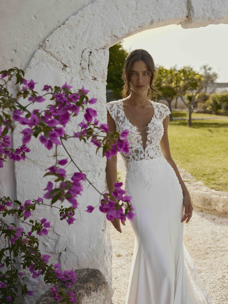 In questa immagine un vestito con scollo profondo di Capri Sposa.