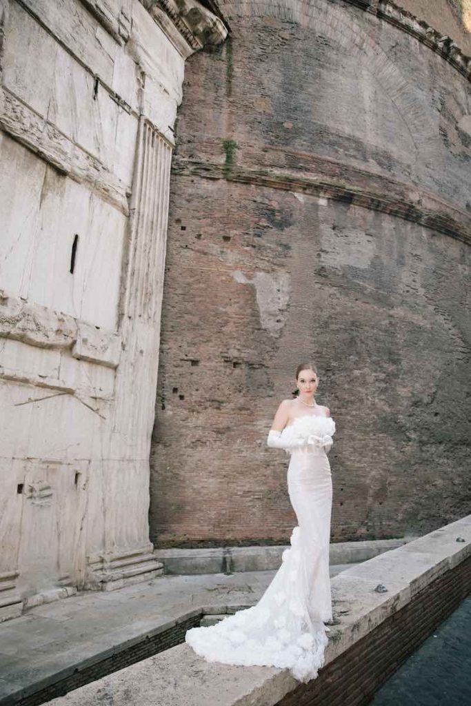 In questa foto una modella posa indossando uno degli abiti da sposa particolari 2024 a sirena con fiori 3D di Bencivenga Alta Sartoria