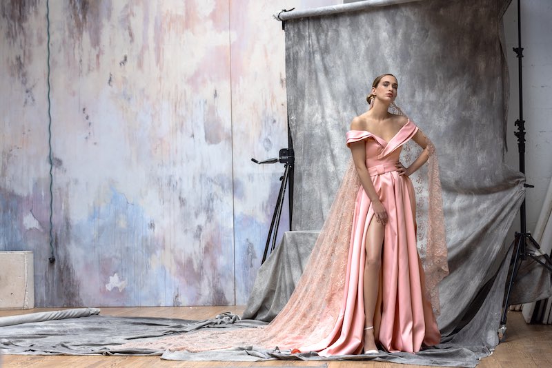 In questa foto una modella posa indossando uno degli abiti da sposa particolari 2024 Cymbeline in mikado di colore rosa