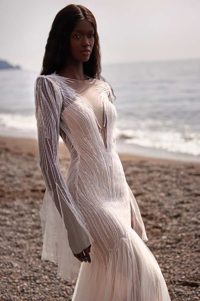 In questa foto una modella posa indossando uno degli abiti da sposa particolari 2024 a sirena di Julie Vino