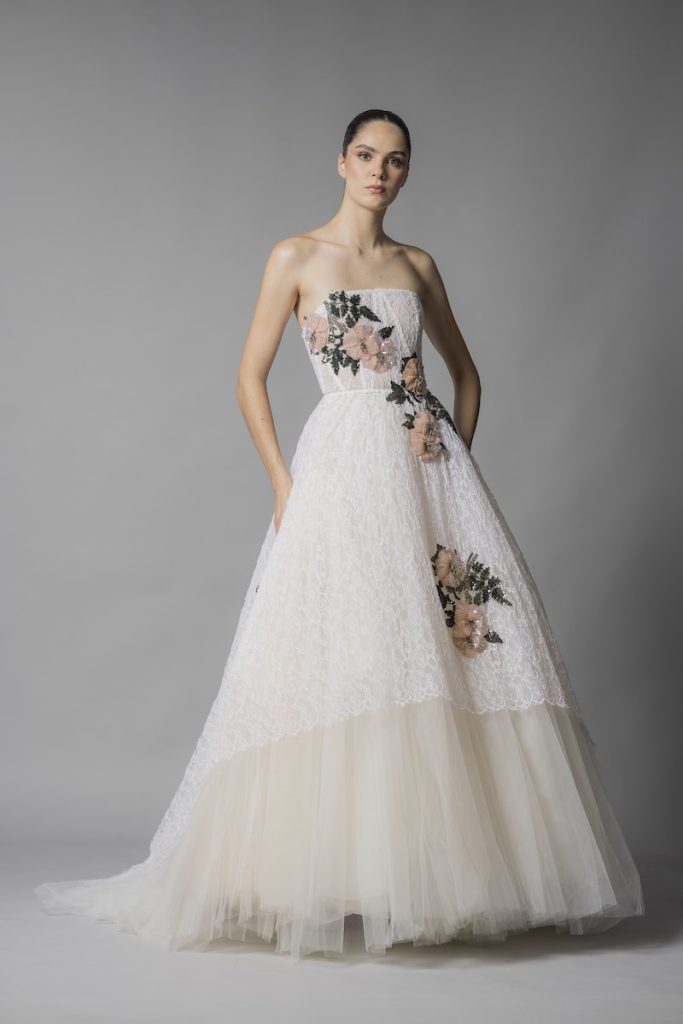 In questa foto una modella posa indossando un abito da sposa ampio con alternanza di stoffe diverse di Marco Y Maria