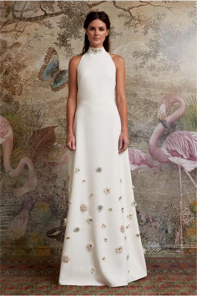 In questa foto una modella posa indossando uno degli abiti da sposa particolari 2024 di Oh Que Luna con fiori 3D in colore pastello