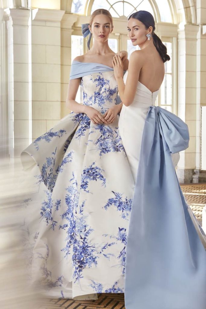 In questa foto due modella posano indossando due abiti da sposa particolari 2024 co fiori e fiocchi di colore azzurro di Sareh Nouri