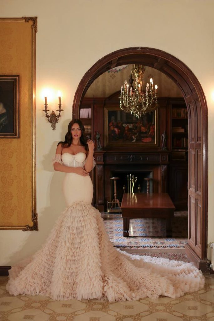 In questa foto una modella posa indossando uno degli abiti da sposa particolari 2024 a sirena di Vladiyan Royal