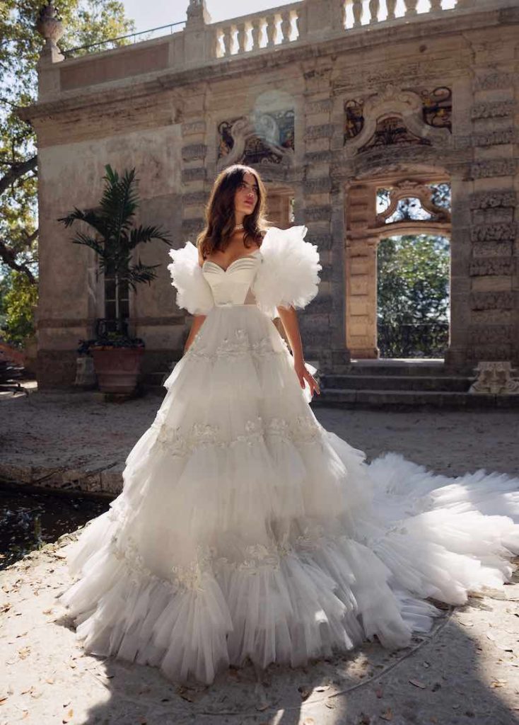 In questa foto una modella posa indossando uno degli abiti da sposa particolari 2024 modello principessa con ruches di Wonà Concept