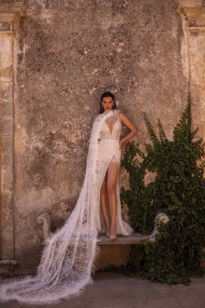 In questa foto una modella posa indossando uno degli abiti da sposa particolari 2024 a sirena con spacco di Elena Morar