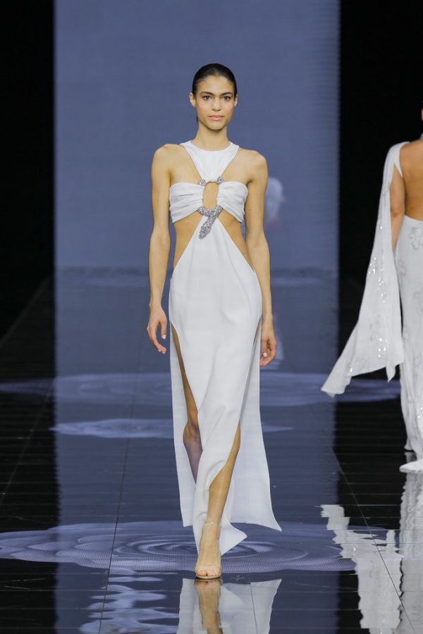 In questa foto una modella posa indossando uno degli abiti da sposa particolari 2024 a sirena con cut out di Isabel Sanchis