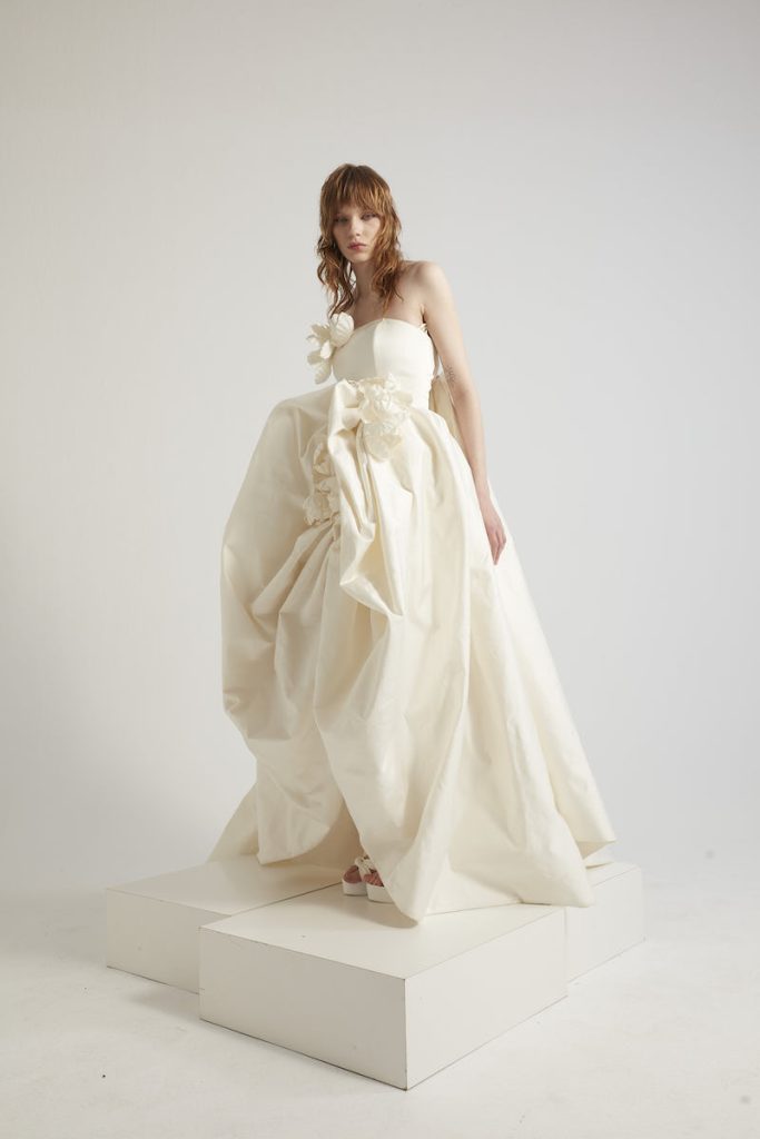 In questa foto una modella posa indossando uno degli abiti da sposa particolari 2024 modello ampio di Yolancris