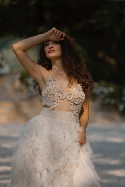 In questa foto una modella posa indossando uno degli abiti da sposa particolari 2024 con crop top di Yoliah Spose