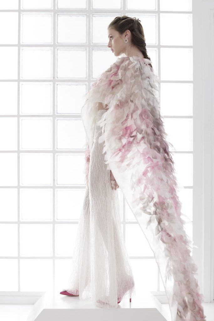 In questa foto una modella indossa un abito da sposa con pantaloni Le Fate Milano Couture abbinato ad una stola con petali 3D con sfumature di rosa