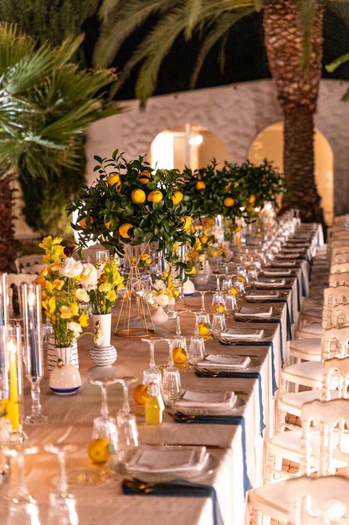 In questa foto un tavolo imperiale allestito con limoni e fiori di colore giallo e bianco in uno dei matrimoni di Angela De Patto