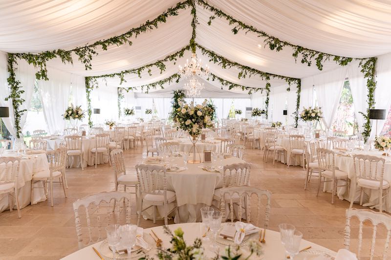 In questa foto la sala di uno dei matrimoni di Angela De Patto allestito con fiori e decorazioni di colore bianco sotto una tende di stoffa
