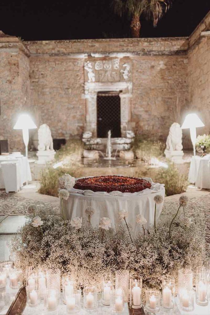 In questa foto l'angolo della torta nuziale del matrimonio di Lucio e Federica decorato dalla Wedding Planner Antonella Candido con gypsophila, rose e candele di colore bianco