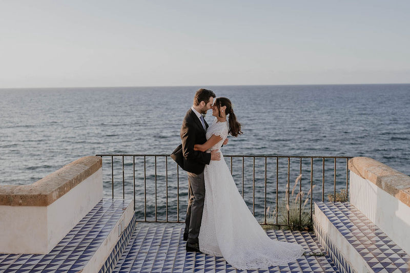 In questa foto gli sposi Lucio e Federica posano sulla terrazza del Castello Lanza di Branciforte sullo sfondo del mare 