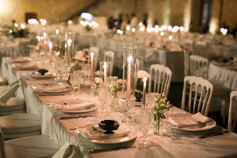 In questa foto un tavolo rettangolare del matrimonio di Lucio e Federica realizzata dalla Wedding Planner Antonella Candido con candele di colore bianco, portacandele in vetro e fiori di colore bianco