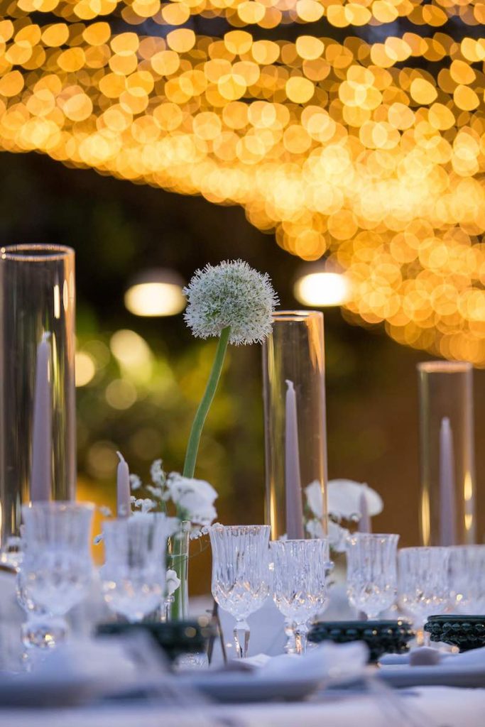 In questa foto un dettaglio della mise en place del matrimonio di Lucio e Federica realizzata dalla Wedding Planner Antonella Candido con candele di colore bianco, portacandele in vetro e fiori di colore bianco