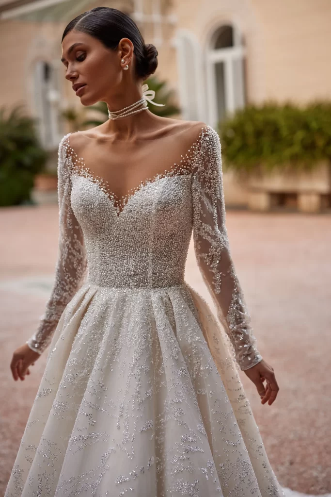 In questa foto la modella indossa un abito da sposa con perline effetto tattoo Pollardi 2024.