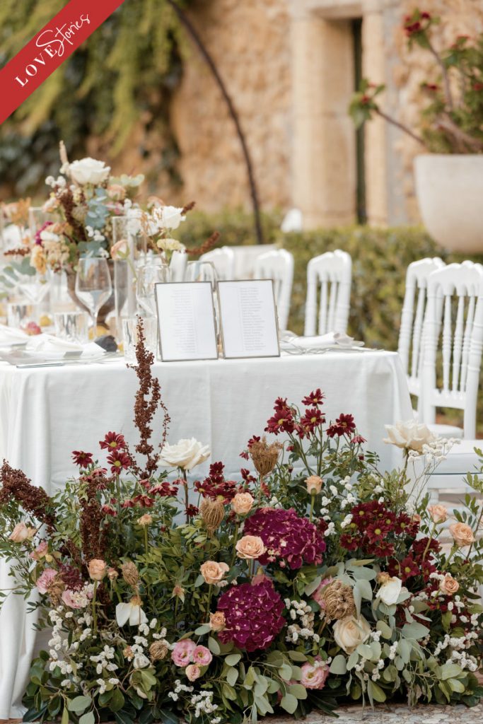 In questa foto un tavolo matrimonio allestito dalla Wedding Planner Antonella Candido con fiori bordeaux, bianchi e rosa tenue 