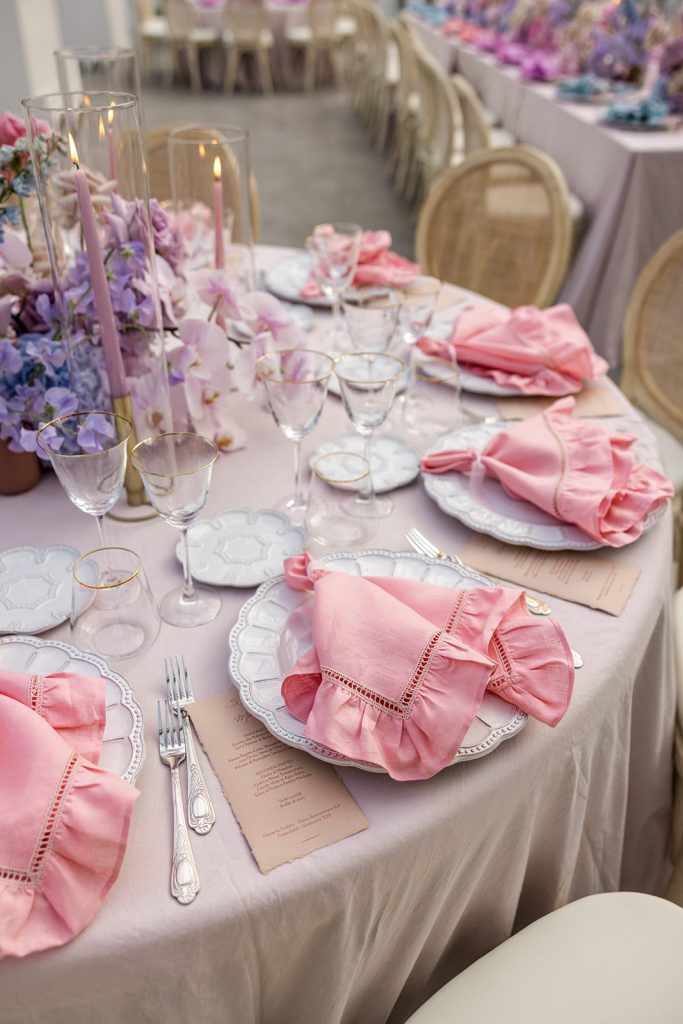 In questa immagine un tovagliolo rosa aperto sul piatto per nozze glamour. 