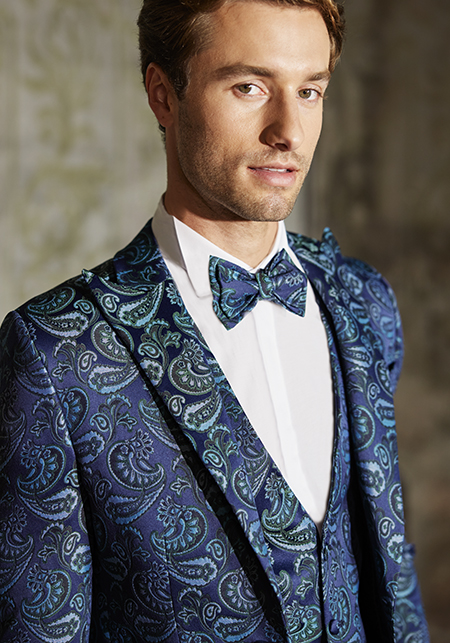 In questa foto il modello indossa un abito da sposo con papillon di tessuto optical blu Musani Couture.