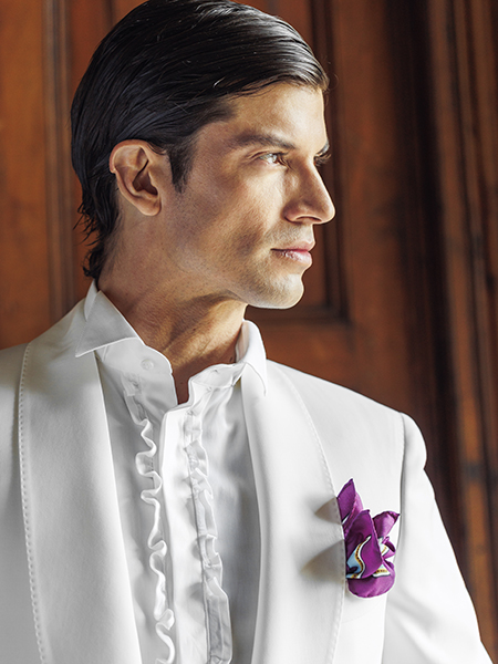 In questa foto il modello indossa un abito da sposo con fazzoletto nel taschino viola Sartoria Rossi 2024.