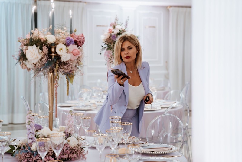 In questa foto la Wedding Planner Barbara Vissani mentre fotografa una mise en place di matrimonio nei toni del lilla, dell'azzurro polvere e dell'oro