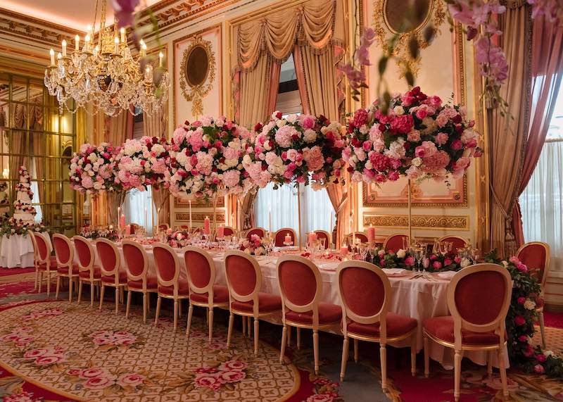 In questa foto un dettaglio di un allestimento di nozze al Ritz di Londra progettato da Barbara Vissani con fiori nei toni del rosa e del fucsia posizionati in alzate disposte lungo un tabolo imperiale