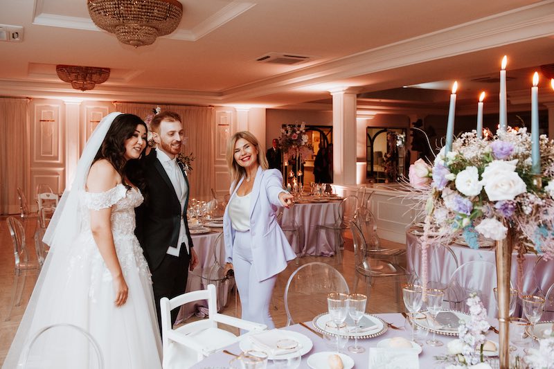 In questa foto la Wedding Planner Barbara Vissani mentre mostra a due sposi la mise en place del loro matrimonio nei toni del lilla, dell'oro e dell'azzurro polvere