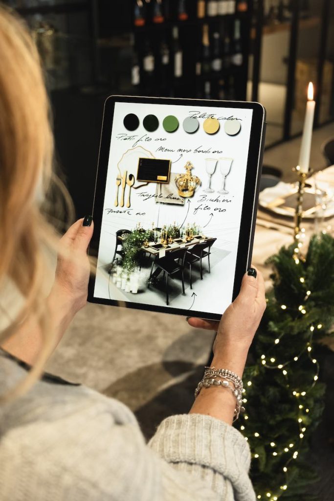 In questa foto la Wedding Designer Claudia Bettini fotografata di spalle mentre guarda un bozzetto di un allestimento realizzato sul suo iPad