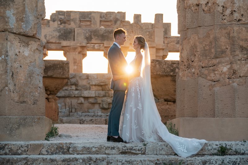 In questa foto gli sposi Vicky e Chris fotografati al tramonto mentre si abbracciano tra le colonne del Tempio di Selinunte