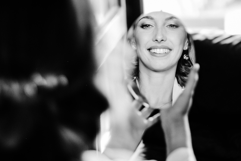 In questa foto in bianco e nero di Fabio Betelli il viso di una sposa che si riflette su un piccolo specchio ovale