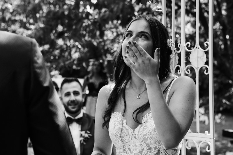 In questa foto in bianco e nero una sposa si asciuga le lacrime durante la cerimonia di nozze