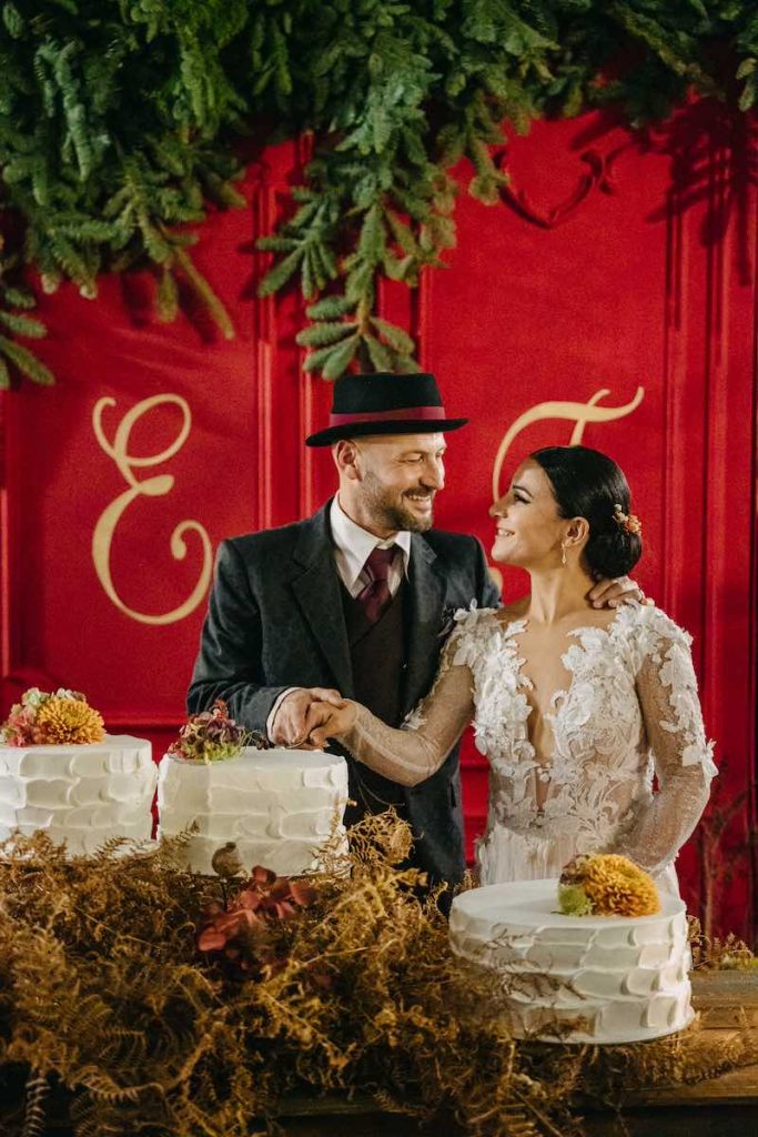 In questa foto gli sposi Tamara e Lorenzo si guardano felici mentre tagliano una delle tre torte del loro matrimonio