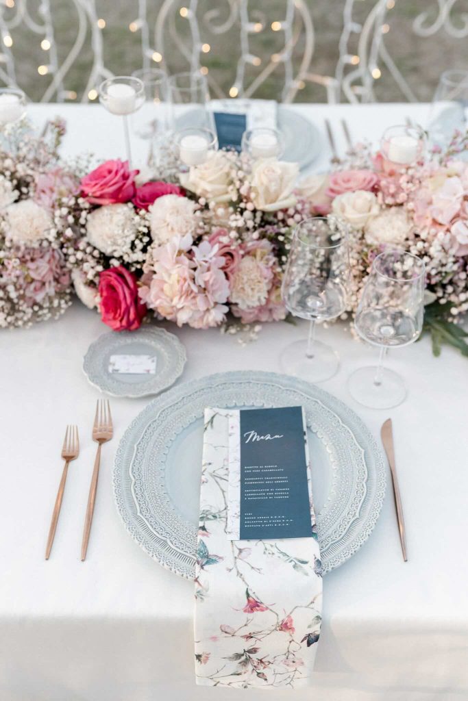 In questa immagine una mise en place matrimonio 2024 con i piatti nelle tonalità dell'azzurro polvere e i tovaglioli floreali. 