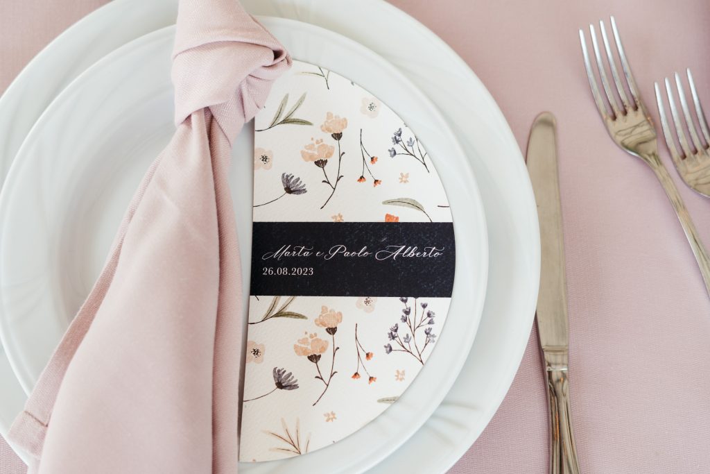 In questa immagine un tovagliolo rosa annodato sul piatto.
