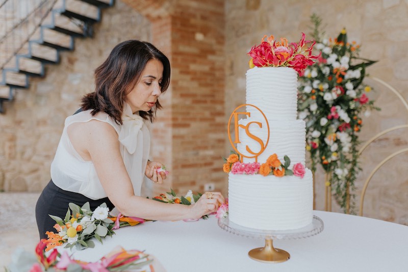 In questa foto la Wedding Planner Elisabetta Alexis mentre sistema gli ultimi fiori sulla torta nuziale degli sposi Francesco e Simona